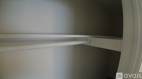 A white shelf with a metal rod on it.