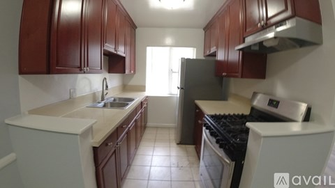 A kitchen with brown cabinets and a stove top oven.