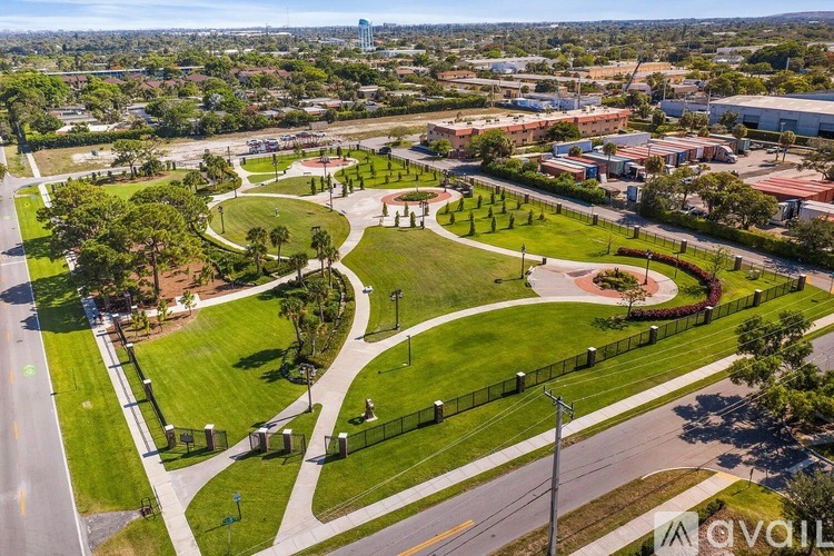 A park with a walking path and a fence.