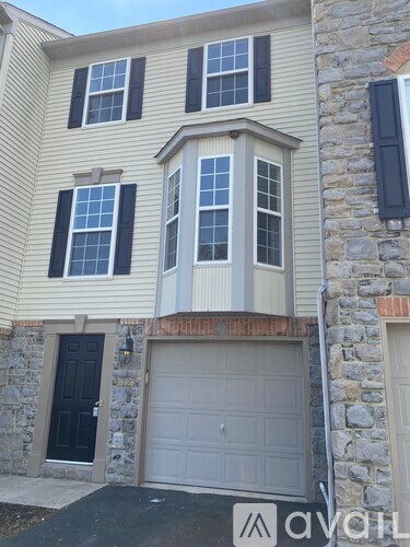 A house with a garage door and a stone wall.