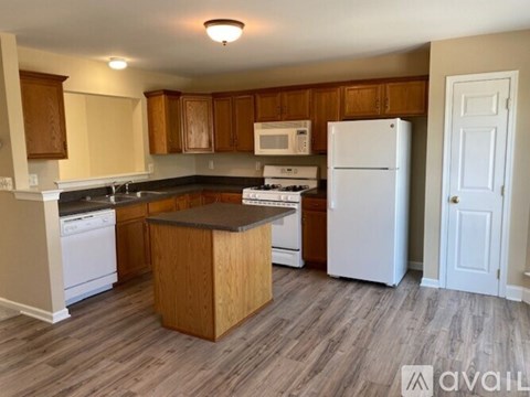 A kitchen with wooden cabinets and a white refrigerator.