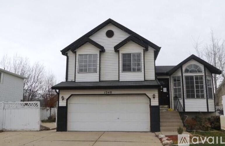 A two-story house with a white garage door is for sale.
