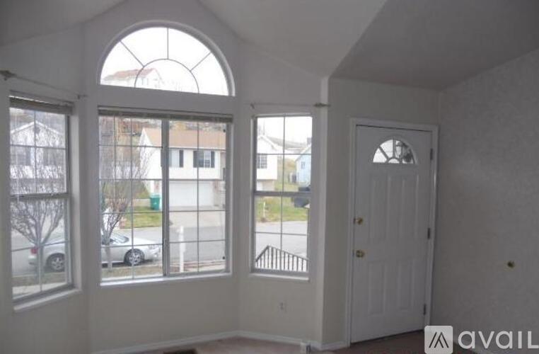 A room with a large arched window and a door.