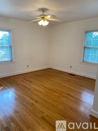 A room with wooden flooring and a ceiling fan.