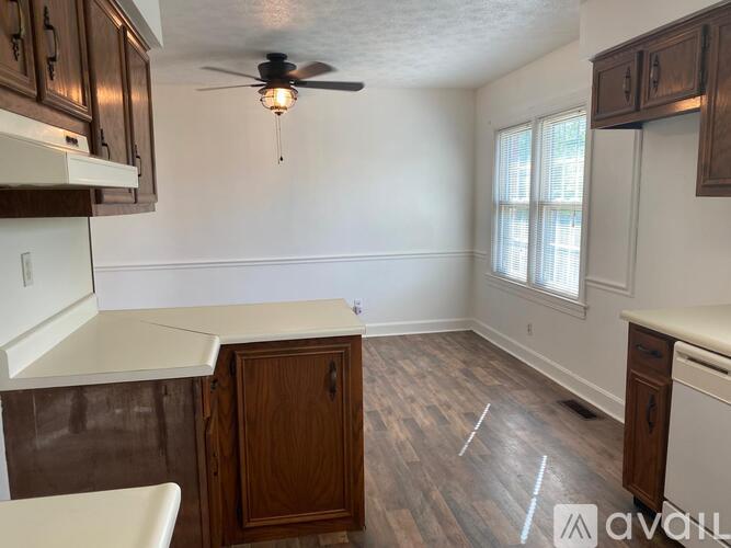 A kitchen with wood cabinets and a ceiling fan.
