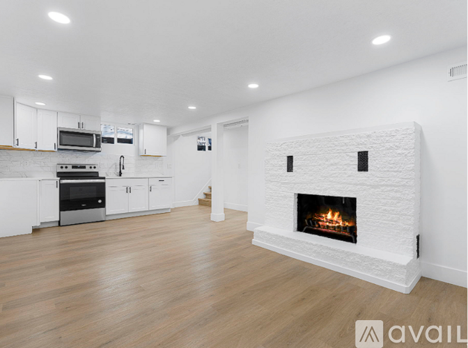 A modern kitchen with a white fireplace in the middle of the room.