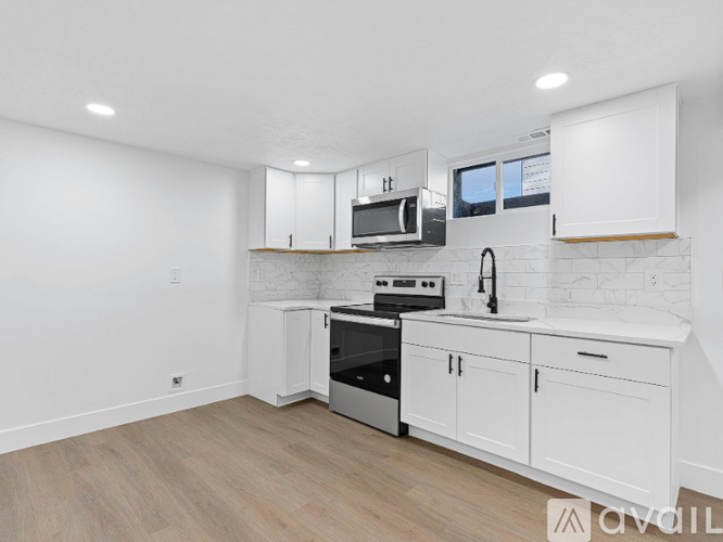 A kitchen with white cabinets and a wooden countertop.