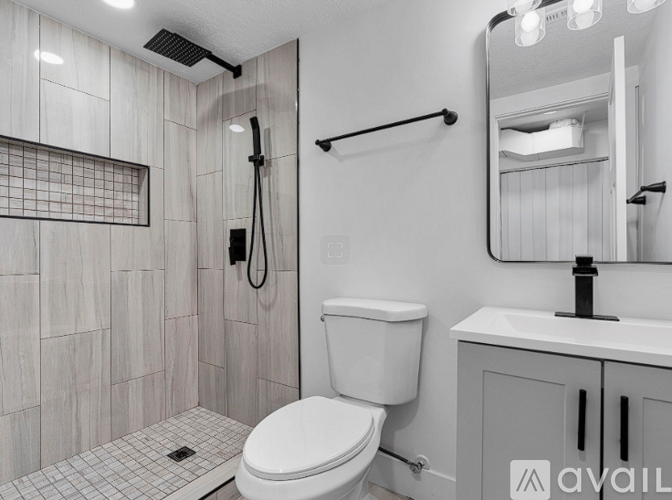A bathroom with a toilet, sink, and shower.