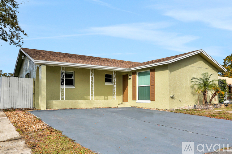 A house with a grey roof and a yellow exterior is for sale.