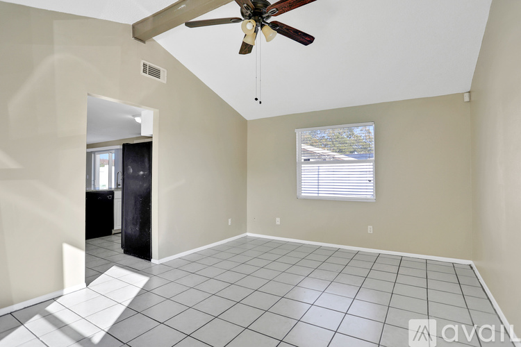 A room with a ceiling fan and a window with blinds.
