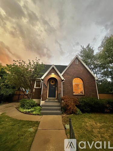 A house with a front yard and a cloudy sky.