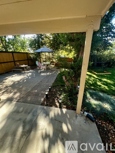 A patio with a table and chairs under an umbrella.