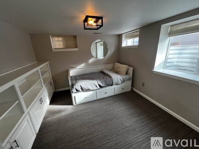 A bedroom with a bed, dresser, and mirror.