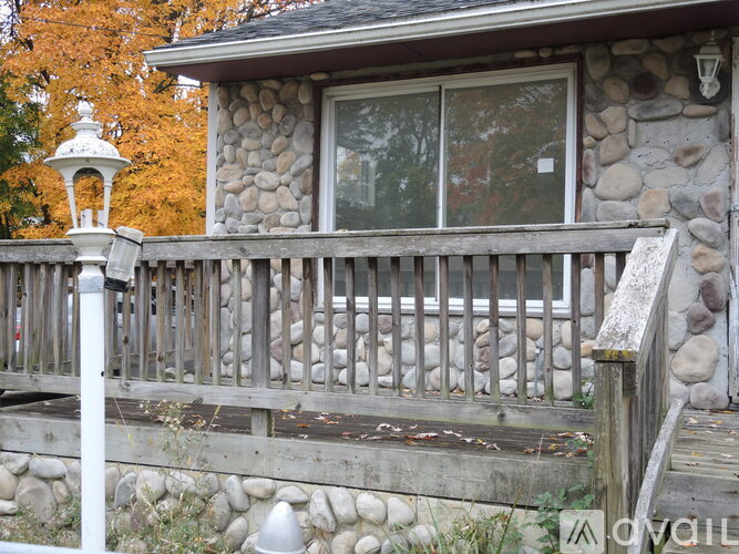 A house with a stone wall and a wooden deck.
