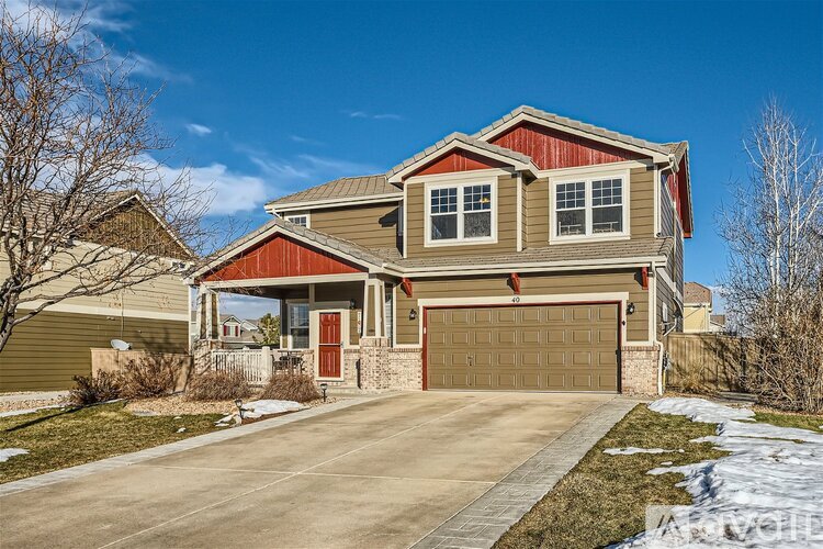 A house with a red and beige exterior and a brown garage door.