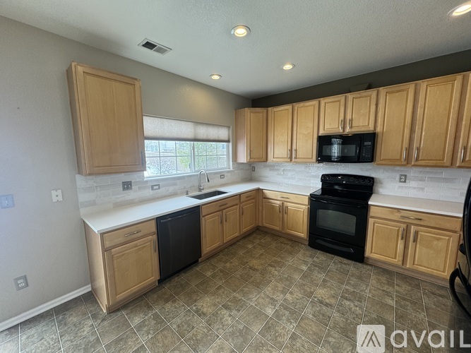 A kitchen with wooden cabinets and black appliances.