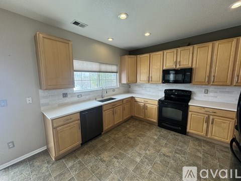 A kitchen with wooden cabinets and black appliances.