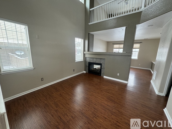 A living room with wood flooring and a fireplace.