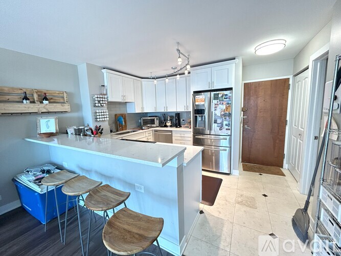 A kitchen with white cabinets and a blue cooler on the counter.