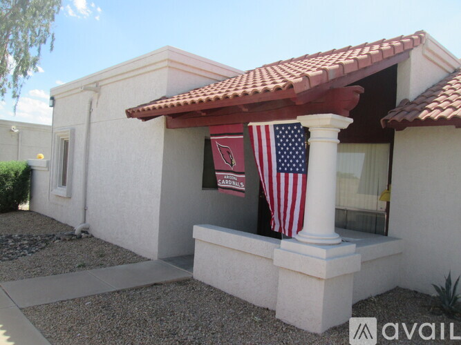 A house with a red tiled roof and a flag on the porch.
