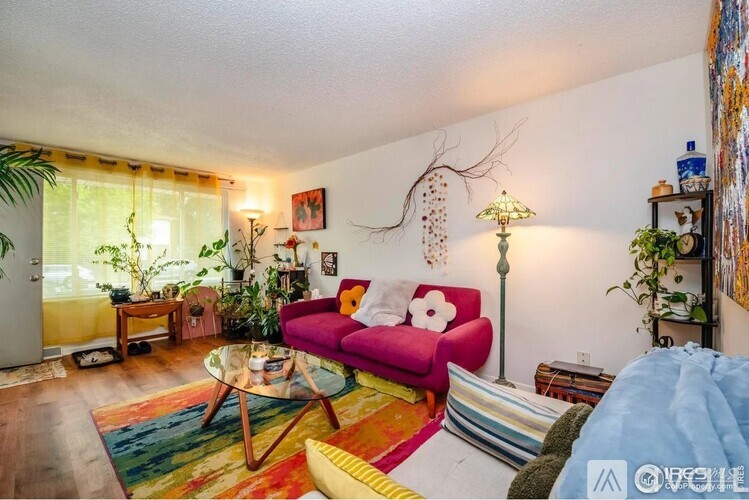 A living room with a red couch and a glass table.