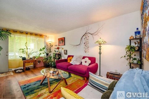 A living room with a red couch and a glass table.