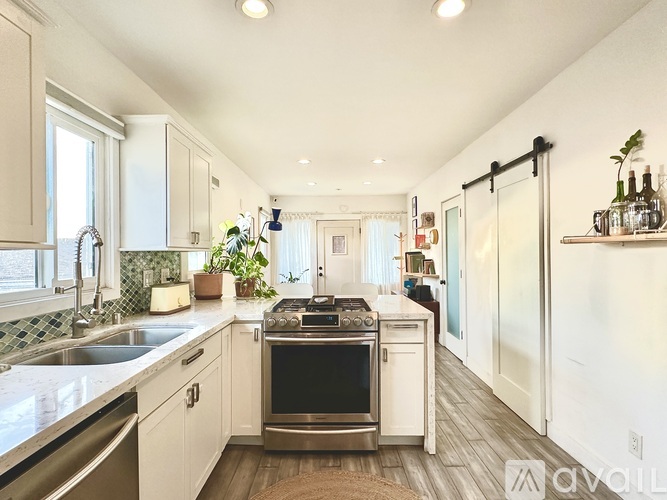 A modern kitchen with a stainless steel oven and white cabinets.