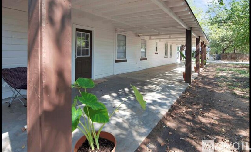 A porch with a potted plant on the left side.