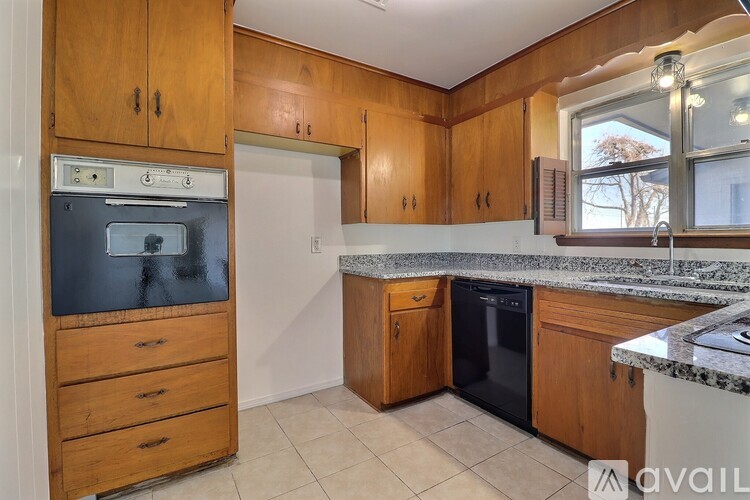 A kitchen with wooden cabinets and a black oven.
