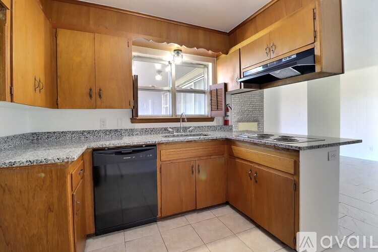 A kitchen with wooden cabinets and granite countertops.