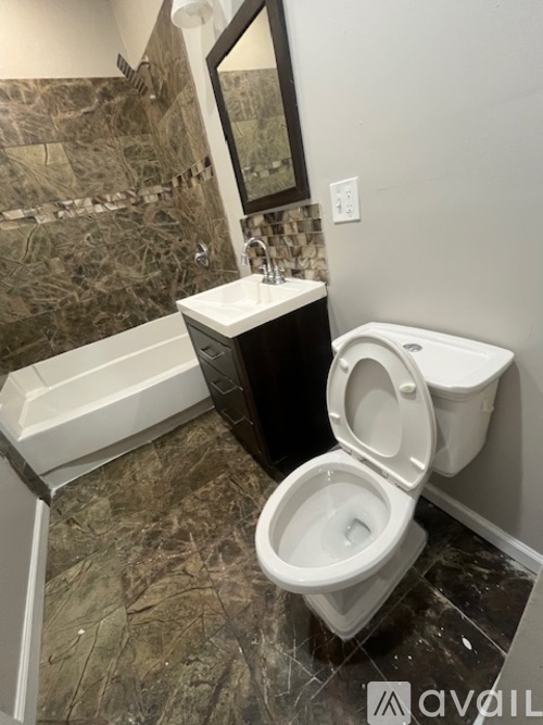 A bathroom with a toilet, sink, and mirror.