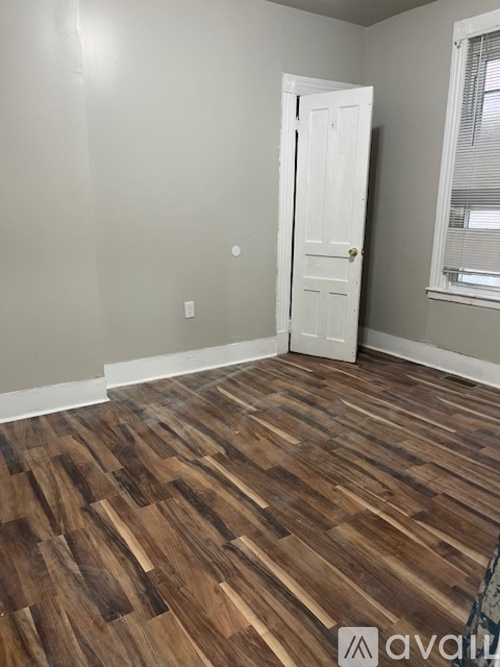 A room with a wooden floor and a white door.