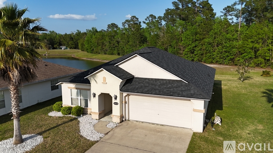 A house with a black roof and a palm tree in front.