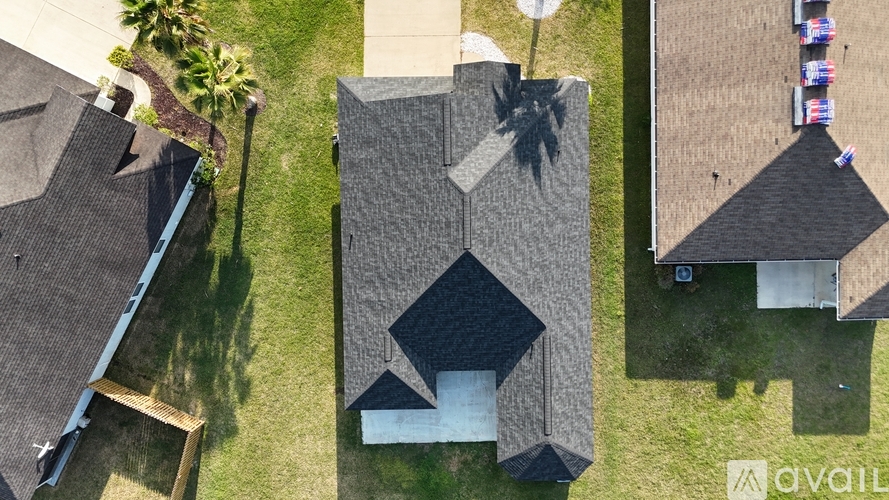 A bird's eye view of a residential area with houses and a palm tree.
