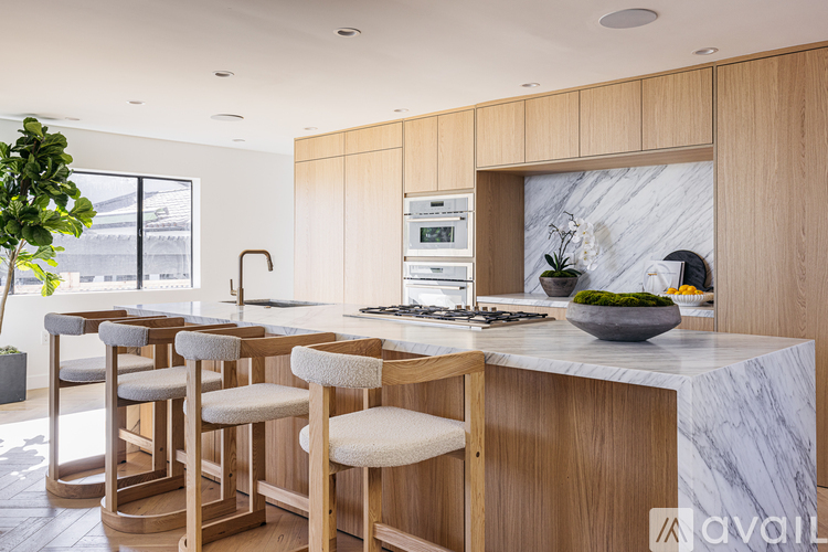 A kitchen with wooden cabinets and a marble countertop.