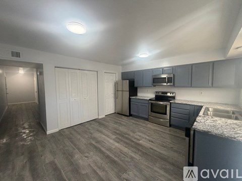 A kitchen with a sink, stove, and cabinets.