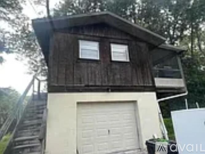 A wooden building with a white door and windows.