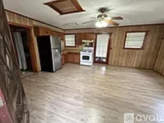 A kitchen with wooden cabinets and a white stove top oven.