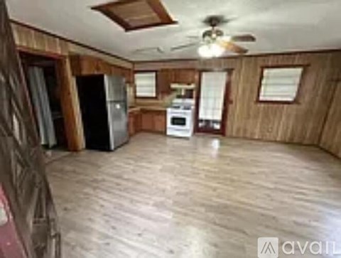 A kitchen with wooden cabinets and a white stove top oven.
