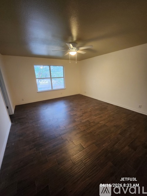 A room with wooden flooring and a ceiling fan.