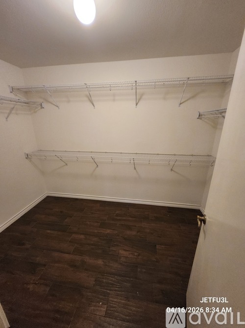 Empty room with white walls and wooden floor.