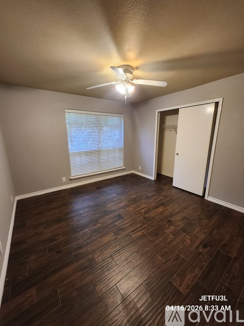 A room with wooden flooring and a ceiling fan.
