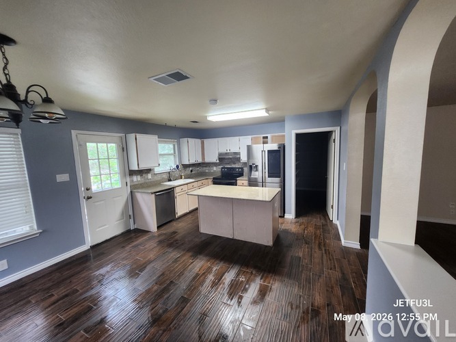 A kitchen with a wooden floor and white cabinets.