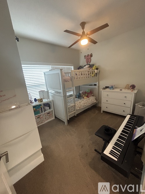A room with a white piano and a bunk bed.