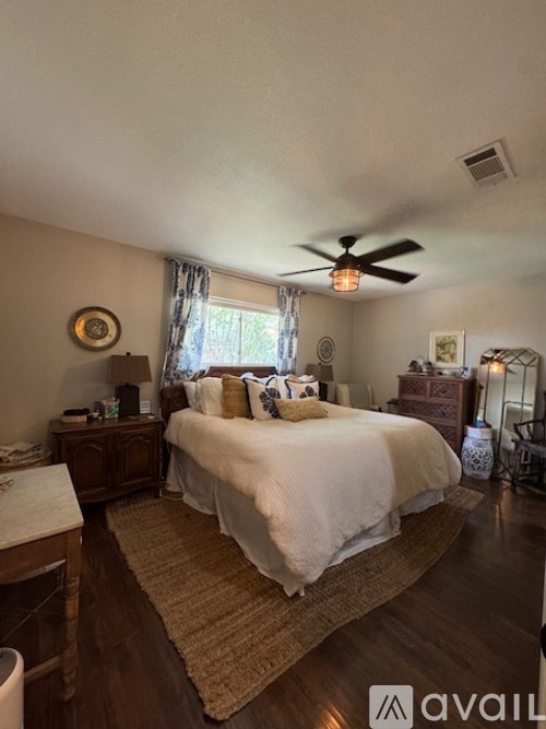 A bedroom with a large bed and a ceiling fan.