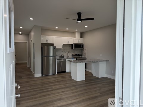 A modern kitchen with a marble countertop and stainless steel appliances.