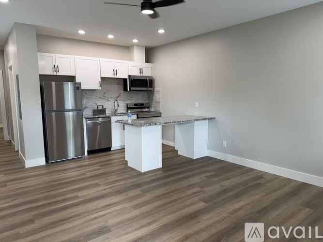 A modern kitchen with a refrigerator, microwave, and stove top oven.