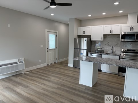 A modern kitchen with a refrigerator, microwave, and oven.