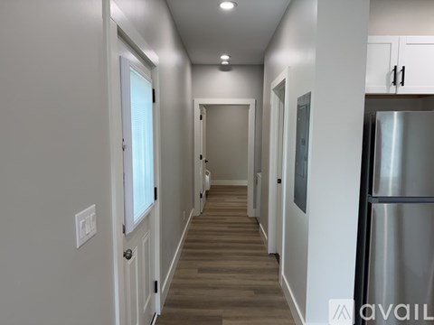 A long hallway with a refrigerator on the right side.