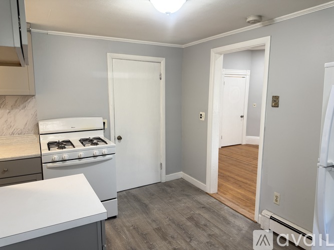 A kitchen with a white countertop and a white stove.